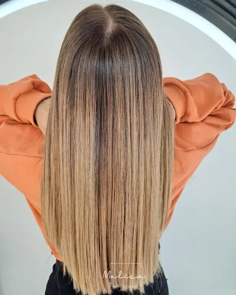 Balayage rubio dorado sobre pelo largo y liso, visto de espaldas
