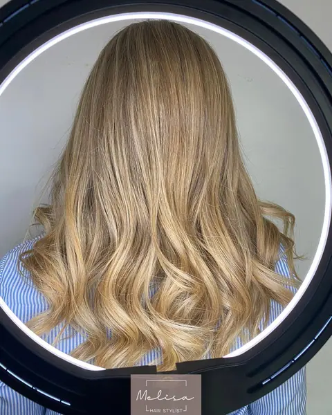 Después: el mismo pelo con balayage rubio y ondas, visto de espaldas